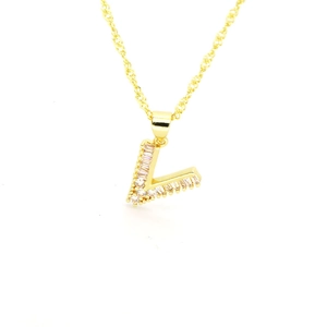 Détail du pendentif lettre V doré orné d'oxydes de zirconium taille baguette