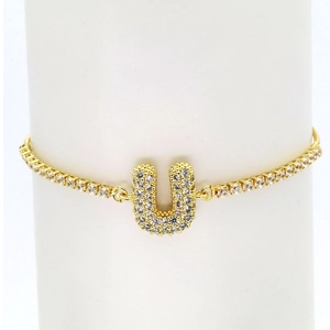 Detail of 18k gold plated tennis bracelet featuring a sparkling zircon pavé letter U charm