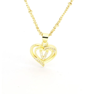 Macro detail of 18k gold heart pendant featuring a sparkling zircon-encrusted letter V