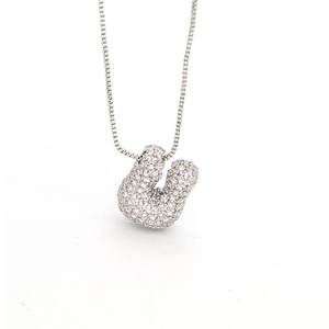 Macro detail of silver letter U bubble pendant necklace with pavé cubic zirconia