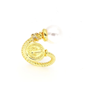 Detail of vintage gold rope ring with a white pearl and embossed coin emblem accent