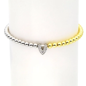 Detailed close-up of mixed gold and silver beads with a crystal-encrusted V pendant