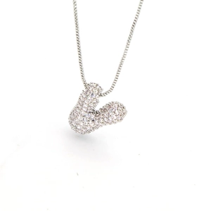 Macro shot of silver V-letter pendant with pavé zircon crystals on a delicate box chain