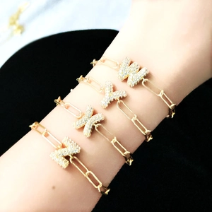 Detail of gold paperclip chain bracelets featuring sparkling zircon balloon letter charms