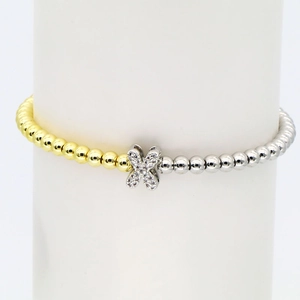 Detail view of 18k gold and silver beads bracelet with zircon-encrusted X-shaped buckle