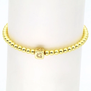 Detail eines 18k vergoldeten Perlenarmbands mit quadratischem G-Buchstaben-Anhänger und Zirkonia