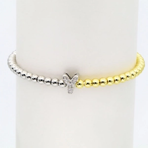 Macro detail of 18k gold plated bubble letter Y charm on two-tone beaded stretch bracelet