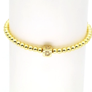 Detail eines 18k Gold-Perlenarmbandes mit einem zirkonia-besetzten Buchstaben-D-Anhänger