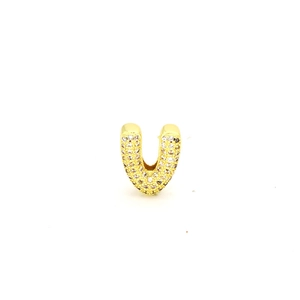 Macro shot of U-shaped gold plated charm with micro pave cubic zirconia stones