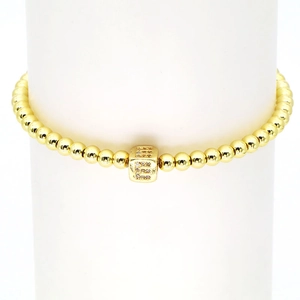 Detailaufnahme eines goldfarbenen Perlenarmbandes mit einem Zirkonia-Buchstabenwürfel E