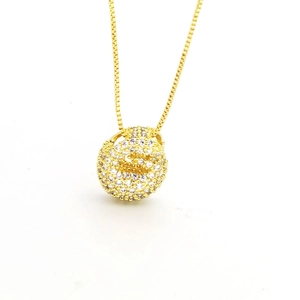 Macro shot of gold necklace with round pendant fully paved in sparkling cubic zirconia