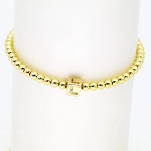 Detail eines 18 Karat vergoldeten Perlenarmbandes mit quadratischem Buchstaben-L-Anhänger