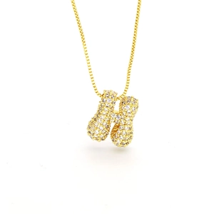 Macro detail of puffy gold letter H pendant necklace with micro-paved sparkling zircon stones