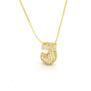 Close-up of golden balloon letter J pendant with cubic zirconia on box chain