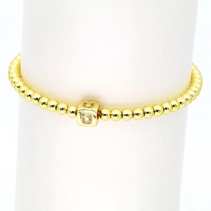 Makroaufnahme des 18k Goldperlen-Armbands mit einem quadratischen Buchstaben-U-Zirkonia
