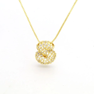 Detailed close-up of a golden double-sphere pendant necklace with micro-pave white zircons