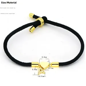 Detail view of adjustable black braided cord bracelet with gold letter A and heart pendant