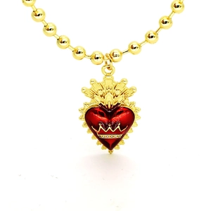 Détail d'un collier à billes dorées avec pendentif cœur rouge et motif couronne
