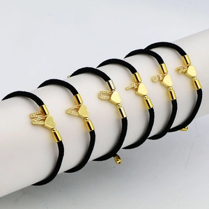 Adjustable heart charm bracelet with gold-plated zircon initial letter on white stand