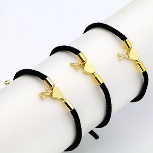Three-piece black woven cord bracelets with golden heart and micro-paved letter pendants