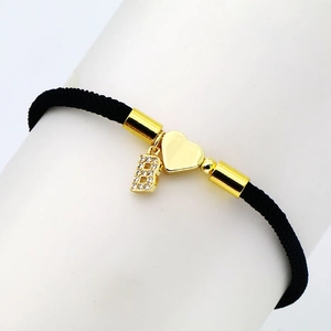 Detail of black woven bracelet with golden heart and micro-pave zircon letter B charm