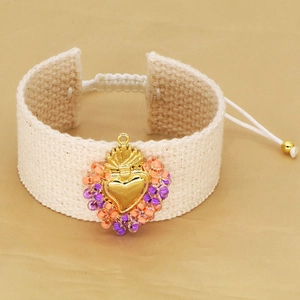 Handmade woven heart bracelet with colorful beads and adjustable golden closure