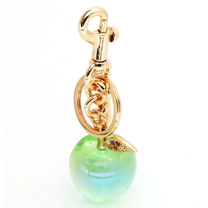 Detail of green resin apple keychain with gold leaf and sparkling colorful rhinestones