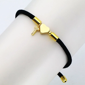 Detail of black woven rope bracelet with gold heart charm and micro-inlaid zircon T pendant