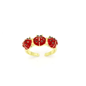 Detail of an open gold ring featuring three cute red enamel ladybugs with black dots