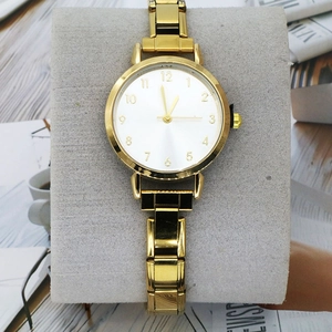 Nahaufnahme der goldenen Quarz-Uhr mit weißem Zifferblatt und Metallarmband auf Halter