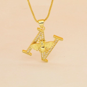 Macro shot of gold letter A pendant with cubic zirconia inlay and a 3D bee detail