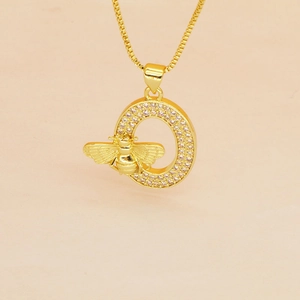 Macro view of gold letter O pendant with pink zircons and small bee detail
