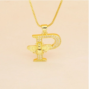 Detailed macro view of gold letter P pendant necklace with tiny zircon stones and bee decor