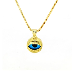 Macro shot of gold Evil Eye pendant with blue iris and radiant textured gold details
