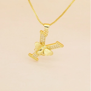 Detail of gold box chain and Y-shaped letter pendant featuring a zircon-studded honey bee