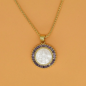 Macro shot of St. Benedict medal pendant with white shell and purple zircon inlay