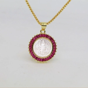Detailed close-up of a golden religious pendant necklace with red square-cut zircons