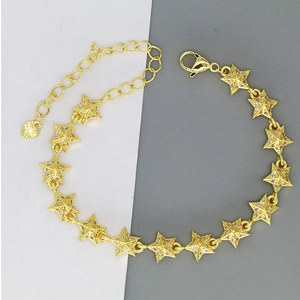 Detail of gold-tone star chain bracelet featuring pavé zircon stars and heart charm