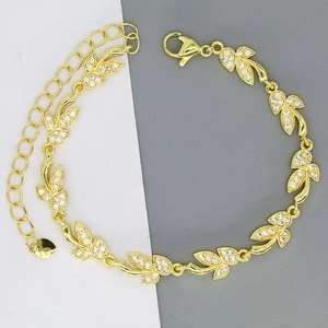 Detailed close-up of golden leaf-shaped link bracelet with white zircon and heart charm