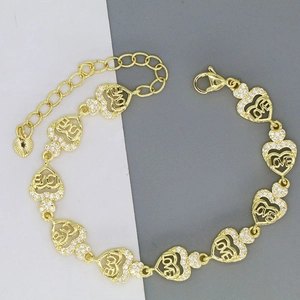 Detailed close-up of golden heart chain bracelet featuring LOVE engraving and zircon stones
