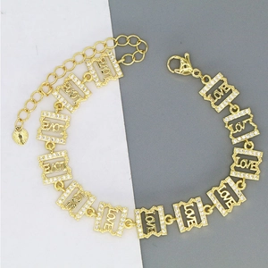 Detail of gold chain bracelet with LOVE letters, cubic zirconia pave, and heart charm