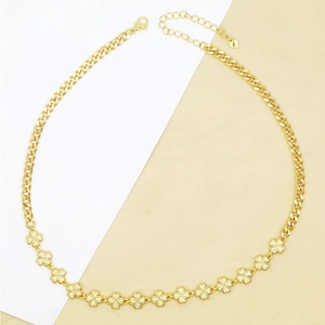 Close-up of golden clover necklace with sparkling white zircons and lobster clasp closure