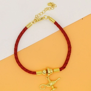 Detail of red braided leather bracelet with golden genie lamp charm and lobster clasp