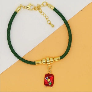 Green leather cord bracelet with golden metal charms and red enamel suitcase pendant