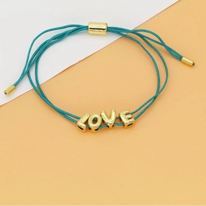 Detailweergave van de verstelbare blauwe gevlochten armband met gouden LOVE letterkralen