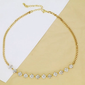 Detail shot of golden clover choker necklace with sparkling rhinestones and cuban chain link