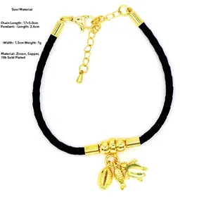Detail of black leather cord bracelet with 18k gold starfish, turtle and shell pendants