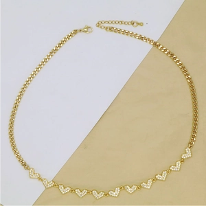 Detail of golden Cuban chain necklace featuring eleven heart pendants with zircon pave