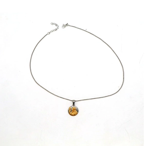 Detail of round religious Saint Benedict pendant necklace with silver and gold finish