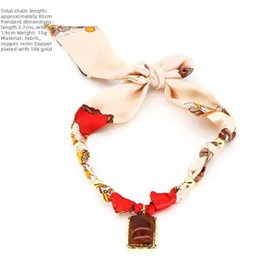 Dettaglio della collana foulard da 85cm con tessuto leopardato e ciondolo in resina placcato oro 18K